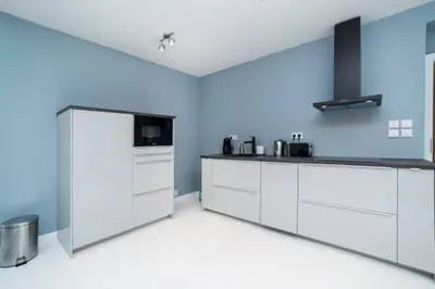 a kitchen with white cabinets and a refrigerator at Old Town 1 Bedroom Oasis with AC and Double Shower in Prague