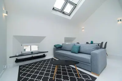 a living room with a couch and a table at Old Town 1 Bedroom Oasis with AC and Double Shower in Prague