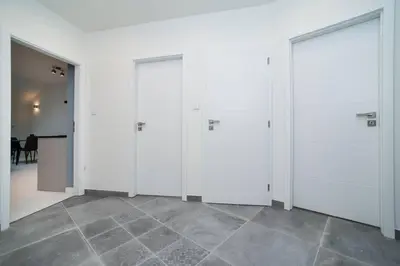 a row of four doors in a room with a tile floor at Old Town 1 Bedroom Oasis with AC and Double Shower in Prague