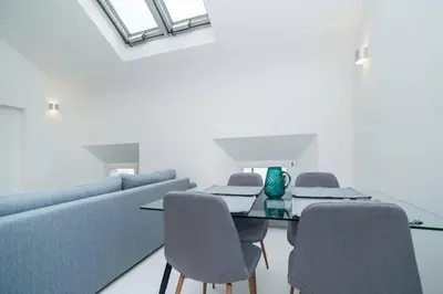 a dining room with a couch and a table and chairs at Old Town 1 Bedroom Oasis with AC and Double Shower in Prague