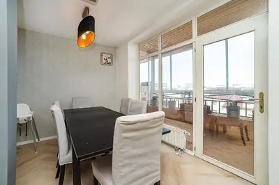 a dining room with a table and a large window at Big 4-bedroom flat, terrace with great Vítkov view in Prague
