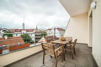 a table and chairs on a balcony with a view at Great Terrace in Big, Central Flat in Prague