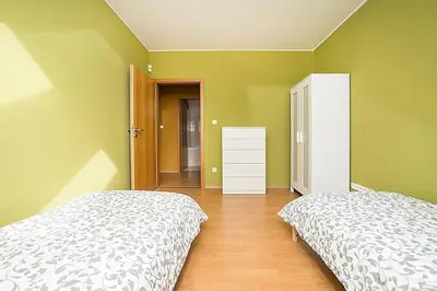 two beds in a bedroom with green walls at Great Terrace in Big, Central Flat in Prague