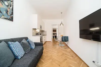a living room with a couch and a kitchen at Newly renovated 1-bed apartment at Charles Bridge in Prague