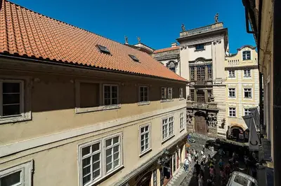 a group of people walking down a street between buildings at Newly renovated 1-bed apartment at Charles Bridge in Prague