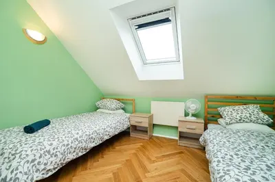 two beds in a room with a window at Central, Spacious, Modern 5 Bedrm duplex w/Balcony in Prague