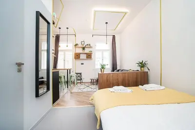 a bedroom with a bed and a dining room at Central designer studio by beautiful park & church in Prague
