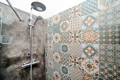 a bathroom with a shower with tiles on the wall at Central designer studio by beautiful park & church in Prague