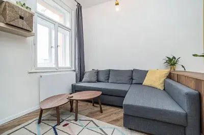 a living room with a blue couch and a table at Central designer studio by beautiful park & church in Prague