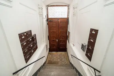 a hallway with a wooden door and stairs in a building at Central designer studio by beautiful park & church in Prague
