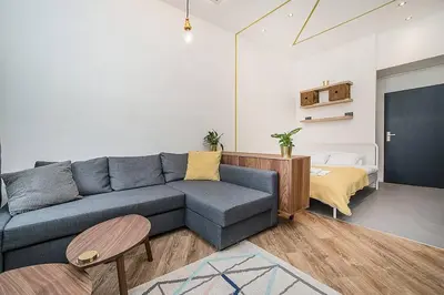 a living room with a blue couch and a table at Central designer studio by beautiful park & church in Prague