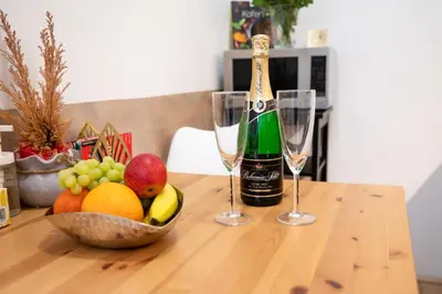 a table with a bowl of fruit and two wine glasses at Premium Wenceslas Square Apartments in Prague