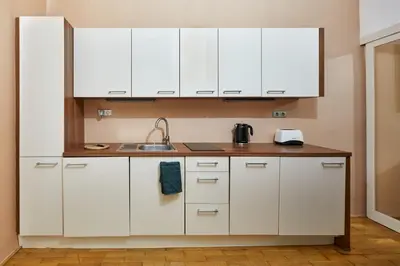 a kitchen with white cabinets and a sink at Prague Days - Studio in the Heart of Prague near Astronomical Clock in Prague