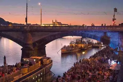 a bridge over a river with a crowd of people at Andel Studio with terrace in Prague