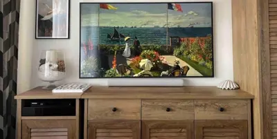 a tv on top of a dresser with a painting at Andel Studio with terrace in Prague