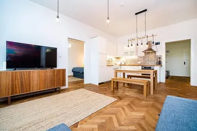 a living room with a television and a dining room at Elegant, modern, 2-bed flat by Museum of Prague in Prague
