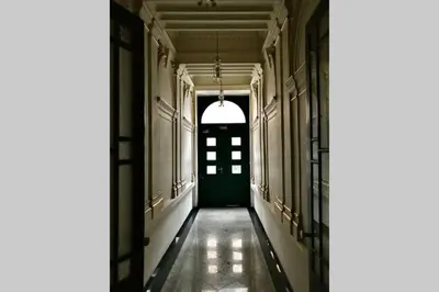 an empty corridor with a green door in a building at Stylový byt v srdci Prahy in Prague