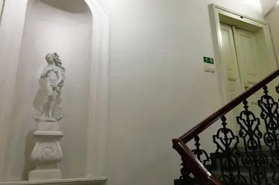 a statue on a wall next to a staircase at Stylový byt v srdci Prahy in Prague