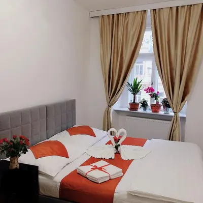 a bedroom with a bed with towels and a window at Lena Apartment in Prague
