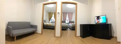 a room with a mirror and a chair and a television at Lena Apartment in Prague