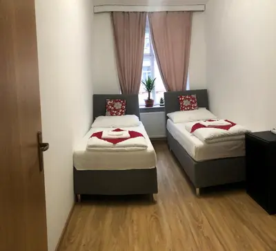 two beds in a small room with a window at Lena Apartment in Prague