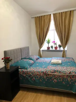 a bedroom with a bed with a blue comforter and a window at Lena Apartment in Prague