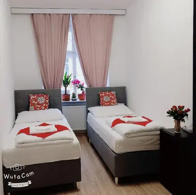 two beds in a room with a window at Lena Apartment in Prague