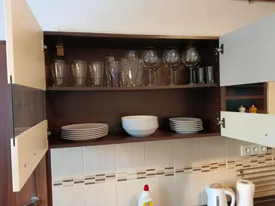 a kitchen cabinet with plates and wine glasses on it at Apartmán Matěj in Poděbrady