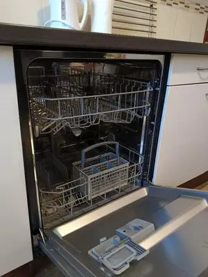 an open dishwasher with dishes inside of it at Apartmán Matěj in Poděbrady