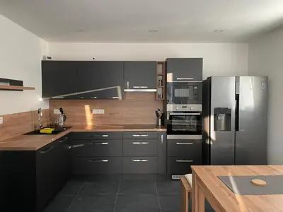 a kitchen with black cabinets and stainless steel appliances at Vilka Petra pod Bezdězem in Weisswasser in Böhmen