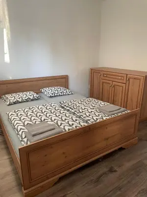 a bed in a bedroom with a wooden bed frame at Vilka Petra pod Bezdězem in Weisswasser in Böhmen