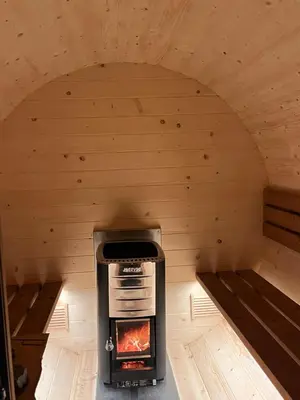 a stove in a sauna with two benches at Vilka Petra pod Bezdězem in Weisswasser in Böhmen