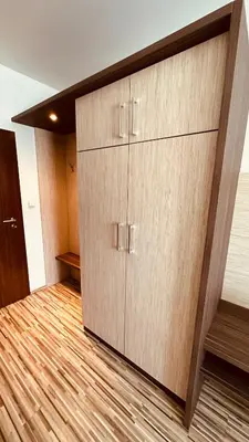 a large wooden cabinet in a room with a wooden floor at Penzion Ranch in Hořovice