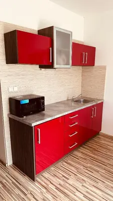 a kitchen with red cabinets and a sink at Penzion Ranch in Hořovice
