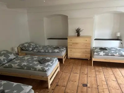 a room with three beds and a dresser at Pivovar Mlýn in Štětí