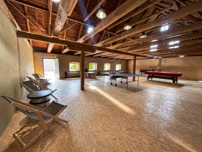 a large room with ping pong tables and chairs at Pivovar Mlýn in Štětí