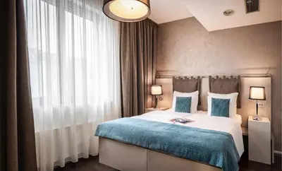 a hotel room with a bed with a blue blanket at VN3 Terraces Suites by Adrez in Prague
