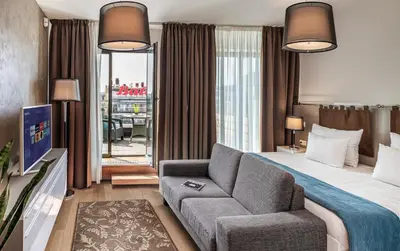 a hotel room with a bed and a couch at VN3 Terraces Suites by Adrez in Prague