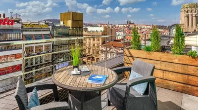 a table and chairs on a balcony with a view at VN3 Terraces Suites by Adrez in Prague