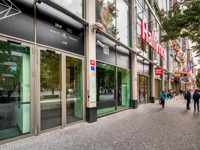 a street with people walking in front of stores at VN3 Terraces Suites by Adrez in Prague