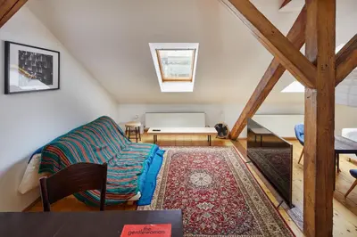 a bedroom with a bed and a chair in a room at Prague Days - Open-plan Duplex with Corner Bath and Netflix in Vinohrady in Prague