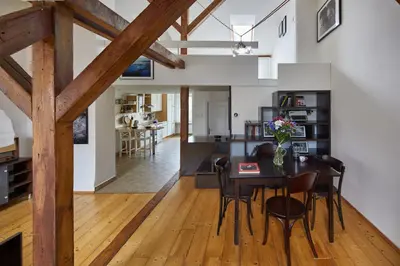 a dining room and living room with a table and chairs at Prague Days - Open-plan Duplex with Corner Bath and Netflix in Vinohrady in Prague