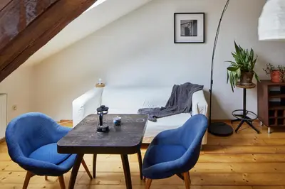 a kitchen with white cabinets and a stainless steel dishwasher at Prague Days - Open-plan Duplex with Corner Bath and Netflix in Vinohrady in Prague