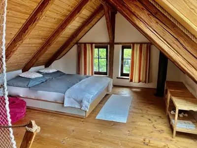 a bedroom with a large bed in a attic at Apartmány pod Kozákem in Velké Popovice