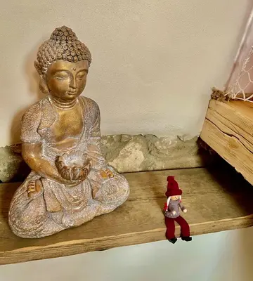 a statue of a woman sitting on a shelf with a toy at Apartmány pod Kozákem in Velké Popovice