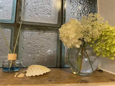 a vase with flowers and a shell on a table at Apartmány pod Kozákem in Velké Popovice