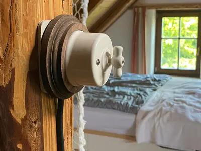 a door knob on a wooden door with a bed at Apartmány pod Kozákem in Velké Popovice