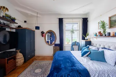 a bedroom with a blue bed and a mirror at Victoria Design Stays - Premium Apartment Ohrada in Prague