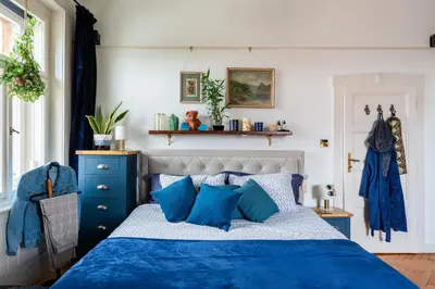 a bedroom with a blue and white bed with blue pillows at Victoria Design Stays - Premium Apartment Ohrada in Prague