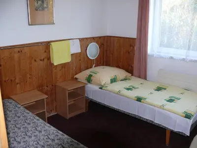 a small bedroom with two beds and a window at Penzion Dana Troja in Prague